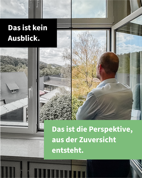 Ein Mann steht an einem Fenster und blickt auf Bäume und die Dächer des Bildungszentrums; die linke Bildhälfte ist grau, die rechte farbig. Im Bild steht „Das ist kein Ausblick. Das ist die Perspektive, aus der Zuversicht entsteht."