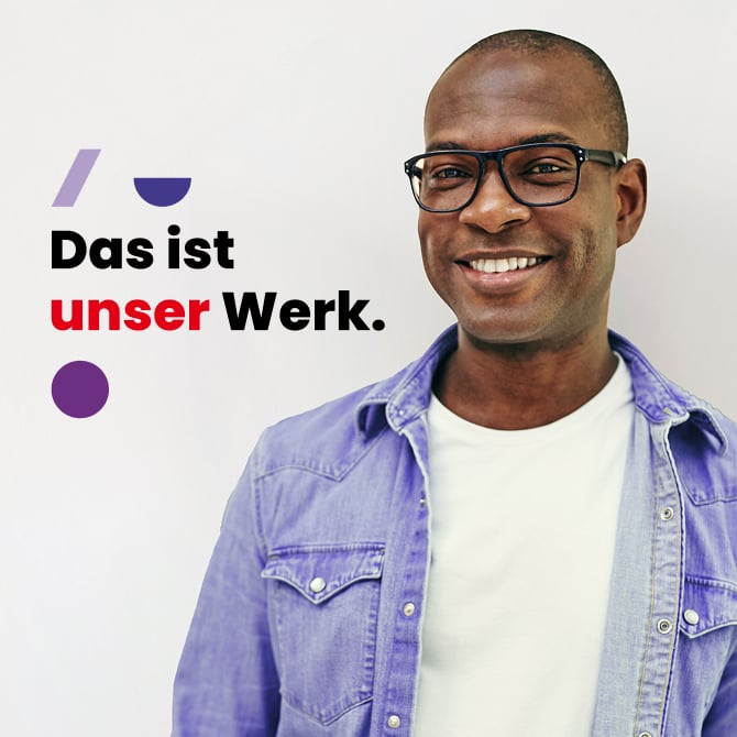 Mann mit Brille lächelt vor weißem Hintergrund; trägt weißes T-Shirt und helles Jeanshemd; links der Slogan ‚Das ist unser Werk.‘ mit lila/roten Formen.