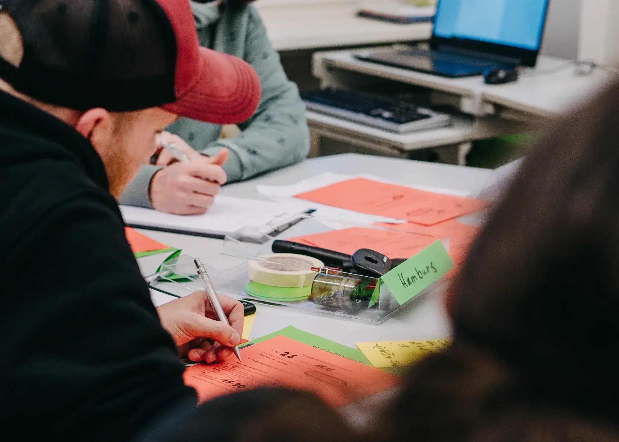 Kleine Gruppe sitzt am Tisch und bearbeitet Notizen