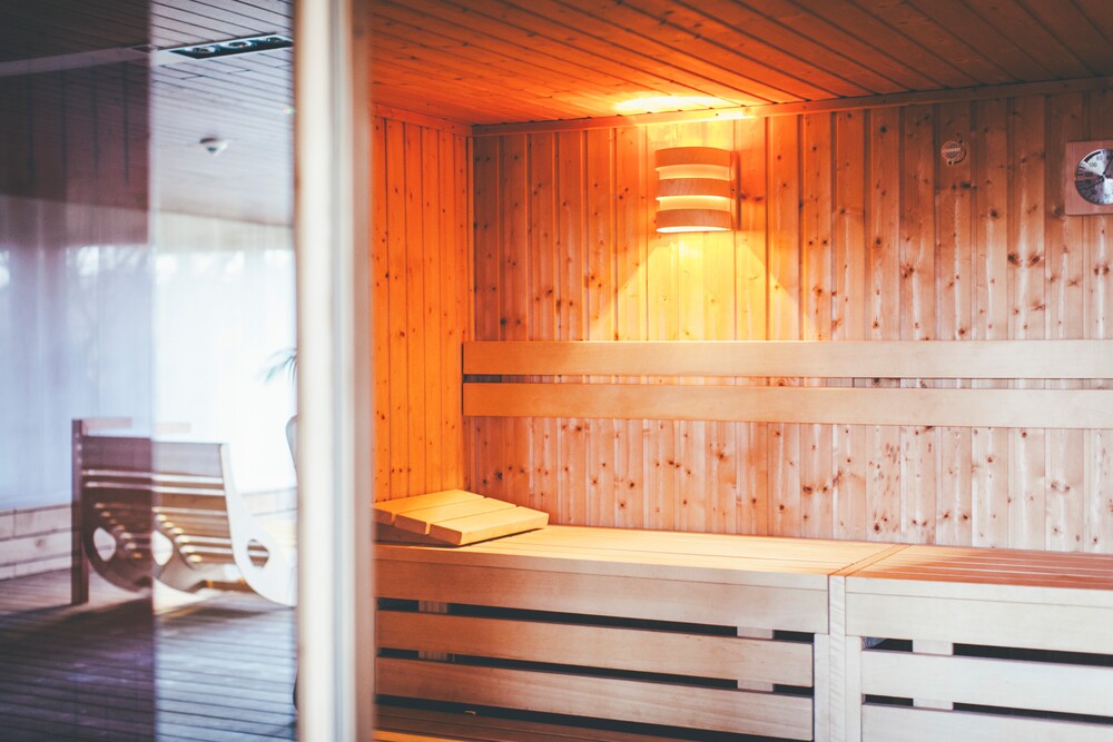 Holzsauna im DGB Tagungszentrum Hattingen mit einer Bank und sanfter Beleuchtung.