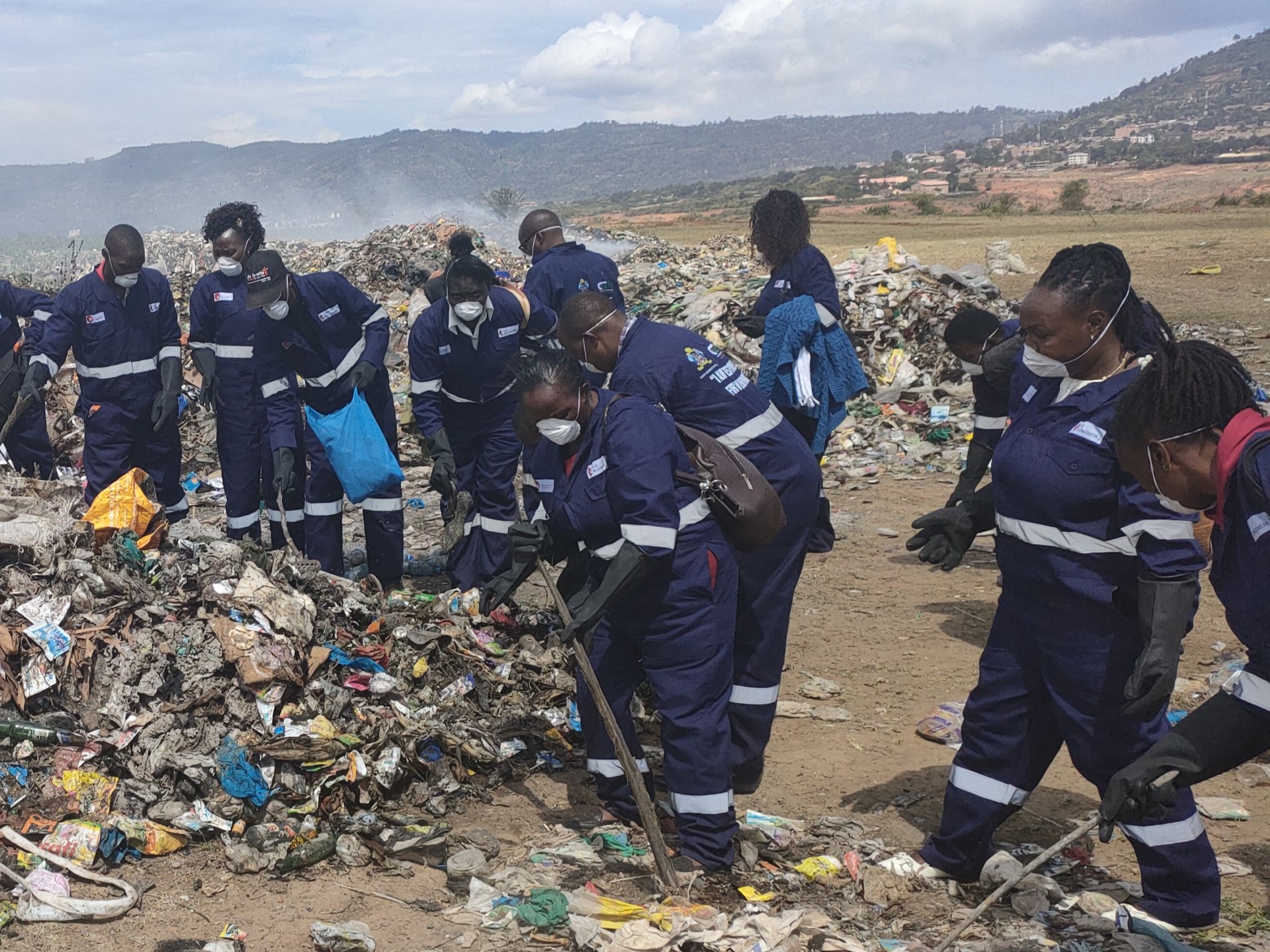 Arbeiter*innen in Schutzausrüstung auf einer Mülldeponie in Kenia.