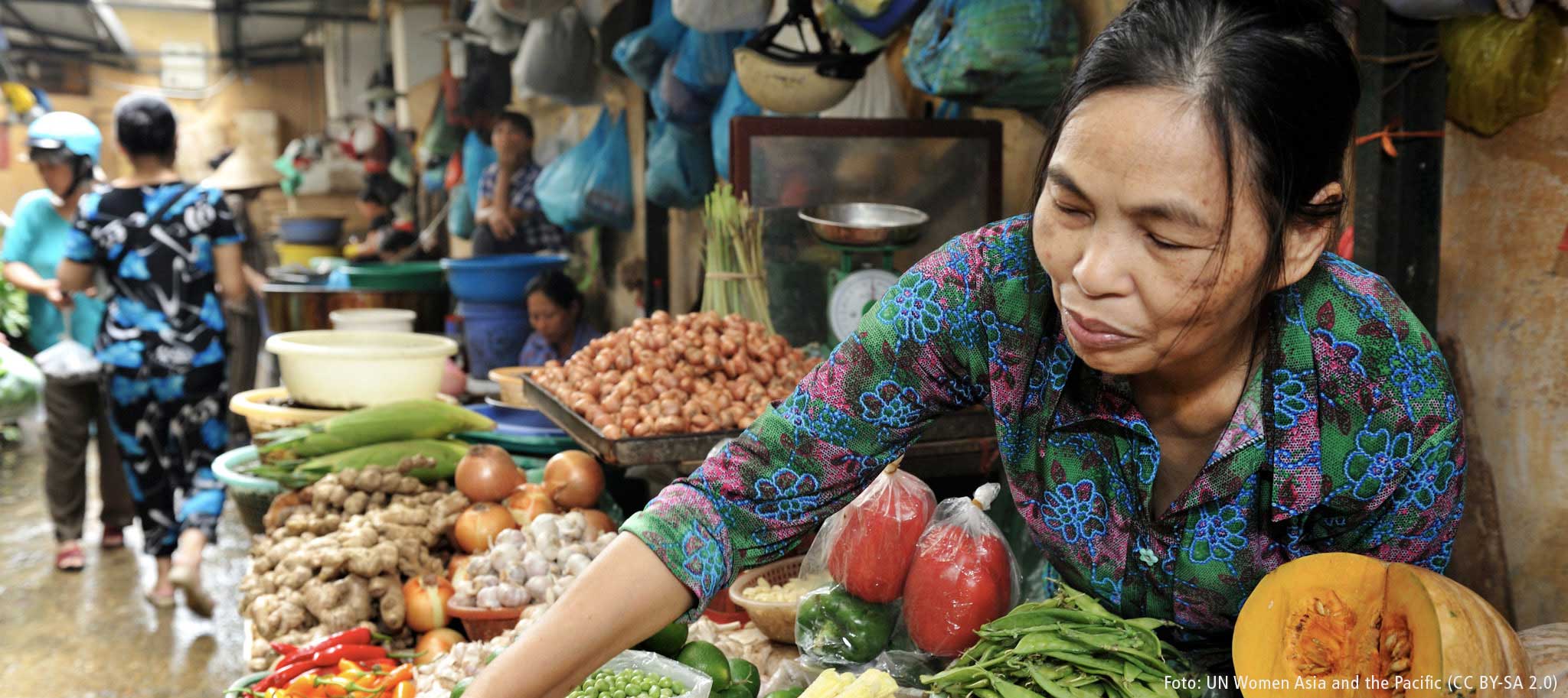 Frau bietet Obst und Gemüse auf einem lokalen Marktstand an.