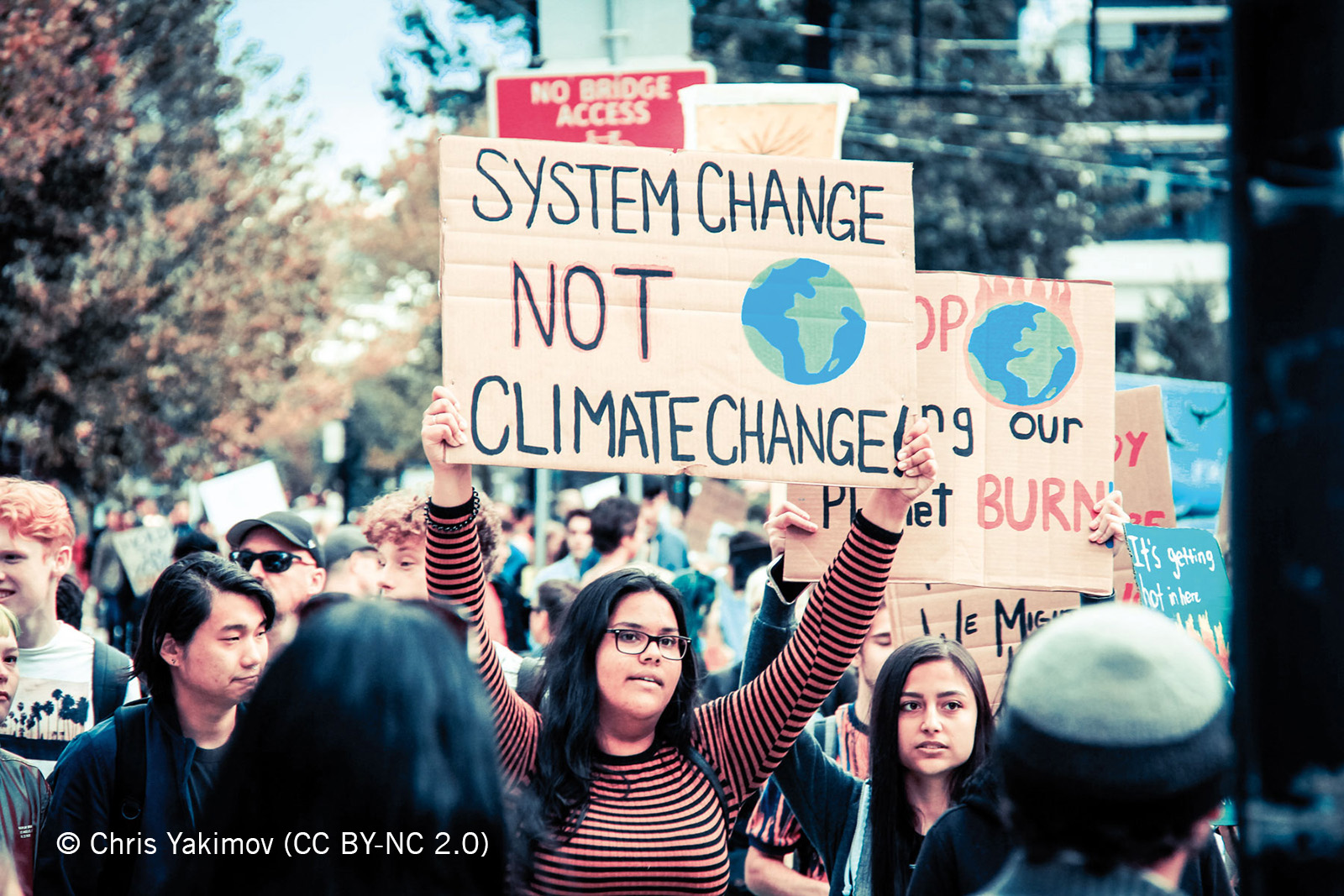 Aktivist_innen halten Plakat auf Protest hoch: System Change Not Climate Change