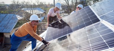 Arbeiter_innen installieren Solarpanels.