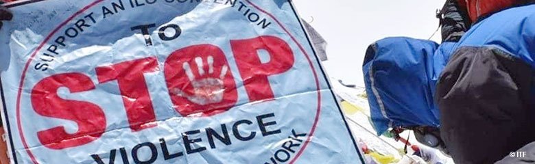 Gewerkschafter hält auf dem Mount Everest Flagge mit der Aufschrift: Support an ILO-Convention To Stop Violence in the world of work.