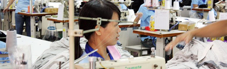Textilarbeiterin an einer Nähmaschine in einer Fabrik in Vietnam