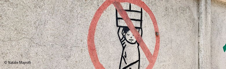 Symbol für Verbot von Kinderarbeit auf einer Mauer.