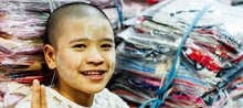 Textilindustrie Myanmar. Junge Person vor Stoffwaren.