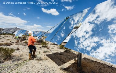 Arbeiter_in reinigt Solarpanel.